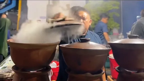 Deretan tungku gerabah mengepulkan asap saat juru masak membuka tutupnya